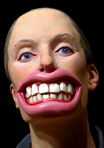 detail of polychromes figurative sculpture of a woman wearing a mask of oversized teeth and lips