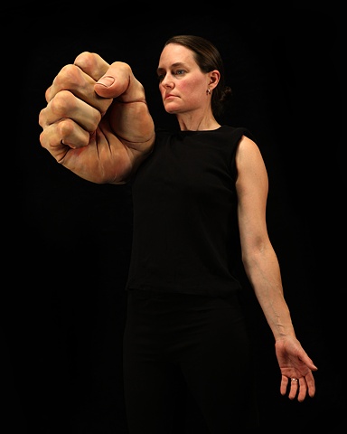 Digital C-Print of  a woman with with a very large sculpted fist on a black background