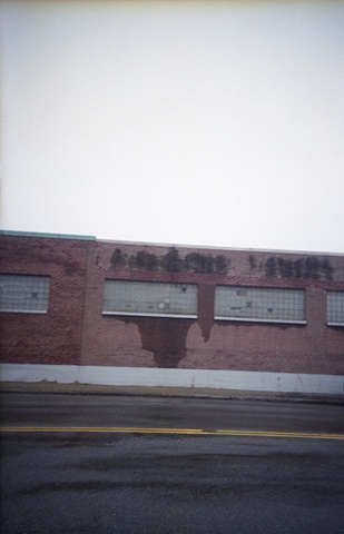 color photograph of brick building and street in rain by iris grimm
