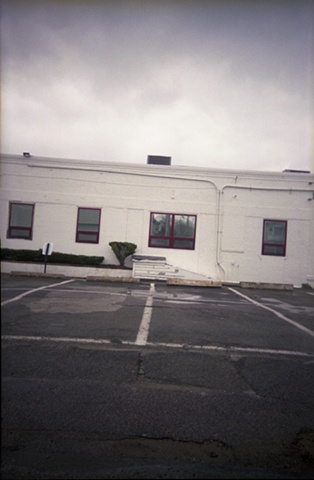 color photograph of an office building and parking lot by iris grimm