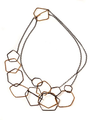  necklace of oxidized silver & brass hexagons & pentagons; adjustable, can be doubled.  