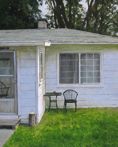 White cottage, green grass, lawn chair.