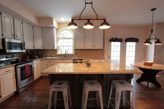White cabinets with cool glaze and accent taupe island 