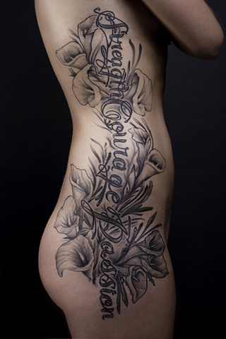 Script lily flower rib tattoo