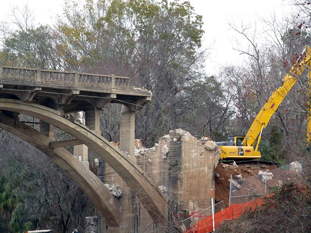 Down river from the bridge.  A crane clears rubble from demolished end on the East side of the Flint.