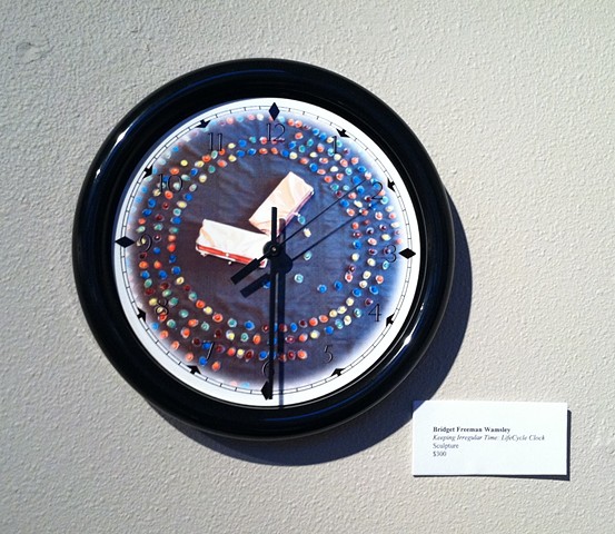 Black rimmed clock with LifeCycle image as the face.