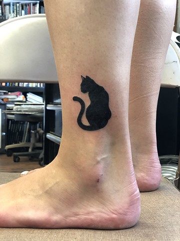 Black cat ankle tattoo by Kc Carew at Gold Standard Tattoo in Bend, Oregon