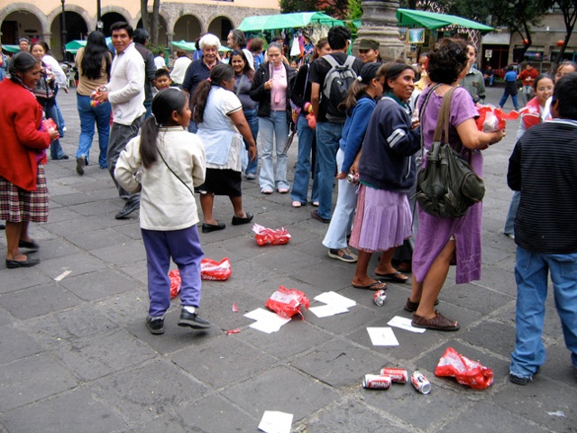 cans of coke are dumped for this art performance with viewer participation in a Mexico City market square