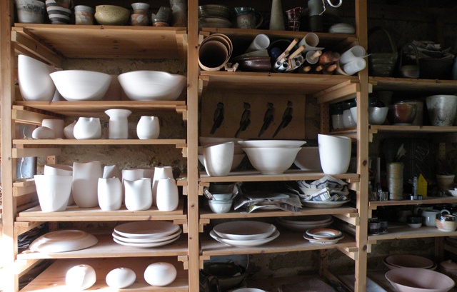 Carol Naughton Ceramics pieces on shelves waiting to be glazed. by Carol Naughton Ceramics