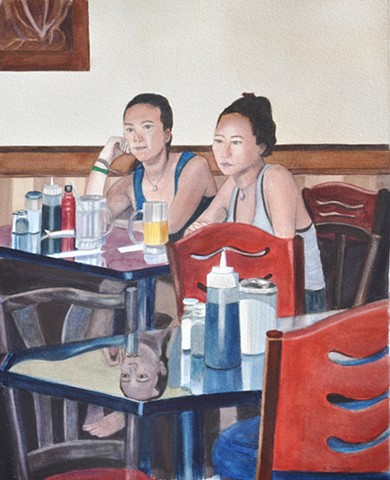 Two young women sit down in a coffee shop, one sad, one seemingly happy
