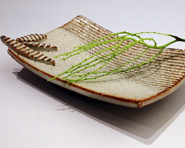 Textured stoneware sushi-plate with applied decoration and glazed with shino and iron oxide