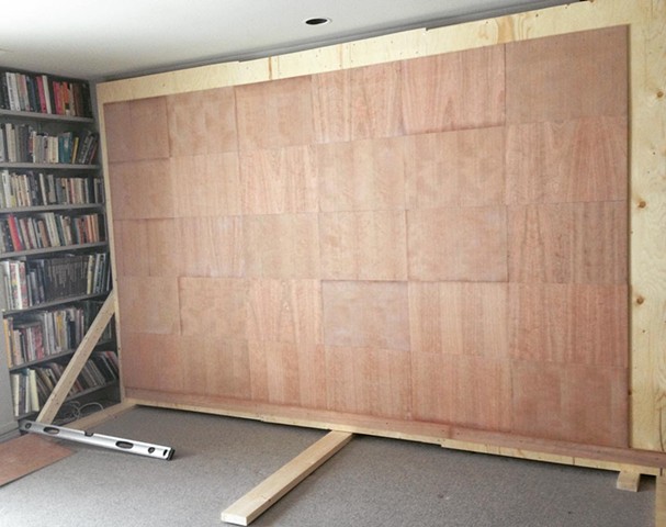 Plywood wall with 30 sanded and varnished cherry panels mounted and ready for drawing