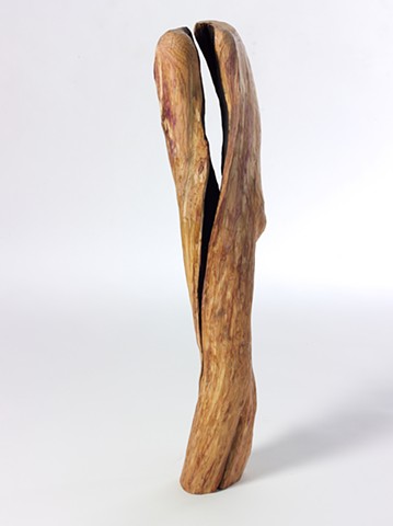 Carved wood sculpture about spaces between by Lin Lisberger