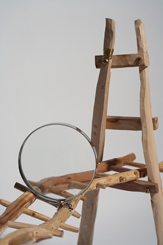 Wood sculpture of bridge with magnifying glass by Lin Lisberger