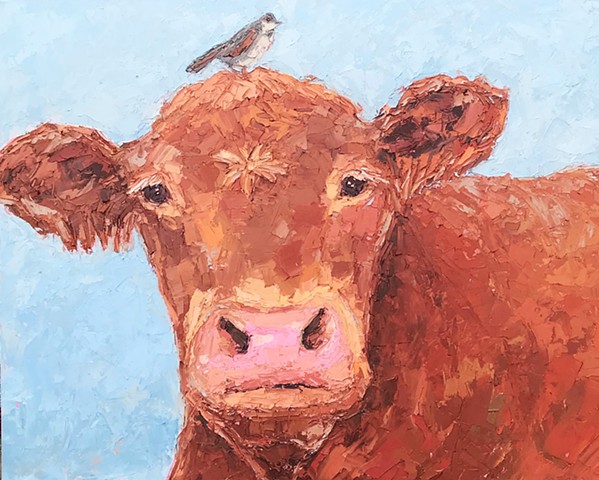 Brown cow with bird on his head