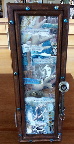 Vertical cabinet constructed with recycled barn wood, light bulb parts, old toy pot handle,collage, verbiage