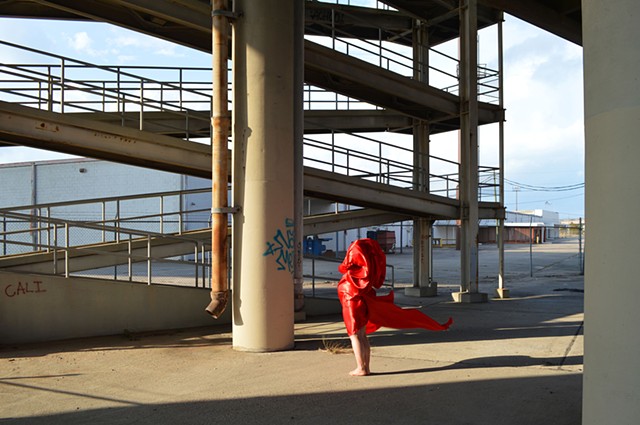 photograph of woman red drapery industrial landscape in New Orleans by Robyn LeRoy-Evans