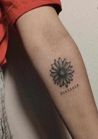 daisy tattoo with a date below Strange World Tattoo Calgary tattoos
