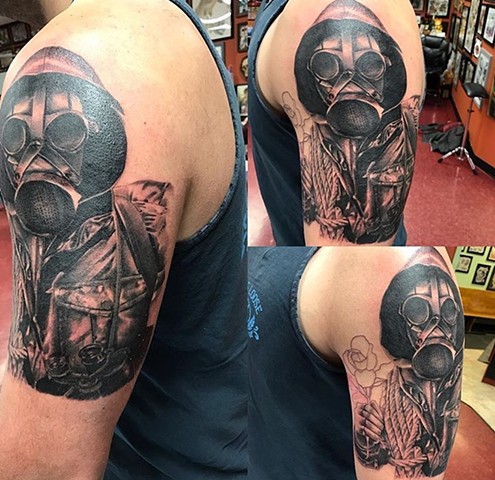 Soldier tattoo with gas mask in black and grey on upper arm Strange World Tattoo Calgary, Alberta Canada