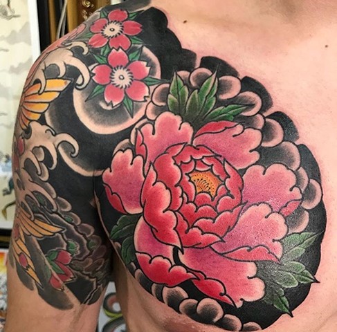 Flower tattoo in chest in colour strange World Tattoo Calgary Alberta Canada 