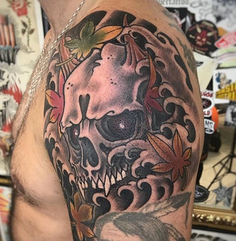 Skull tattoo on upper arm Strange World Tattoo Calgary Alberta Canada 