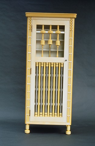 Tall cabinet, fretwork in door formed by salvaged braided stainless steel jet fuel lines. 