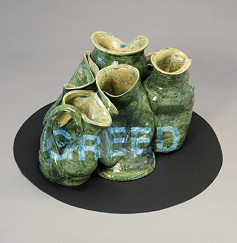 Wheel thrown and altered ceramic vessels with projected text "Greed" by Linda S Fitz Gibbon