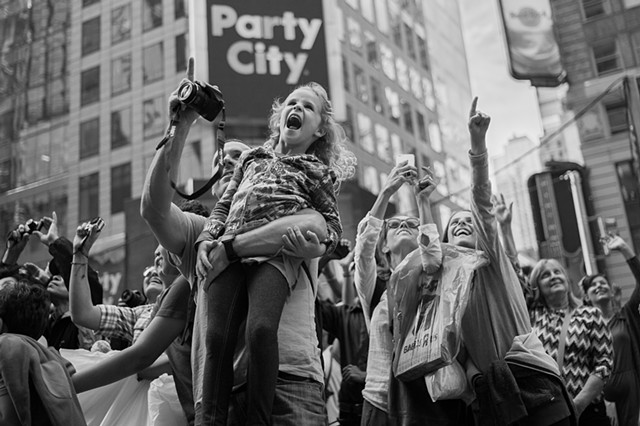 Photograph of a girl on her father's shoulders, Times Square, Manhattan, NY, by Judith Ebenstein