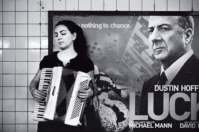 Photograph off an Accordionist with a Poster of Dustin Hoffman, 14th St Subway Station, Manhattan, New York, by Judith Ebenstein