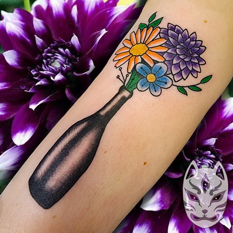 Traditional style tattoo of flowers in a vase on upper arm by Gina Matuo of Copper Fox in Kissimmee Florida