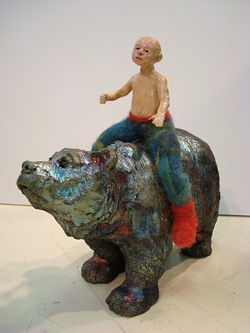 small boy rides a raku bear