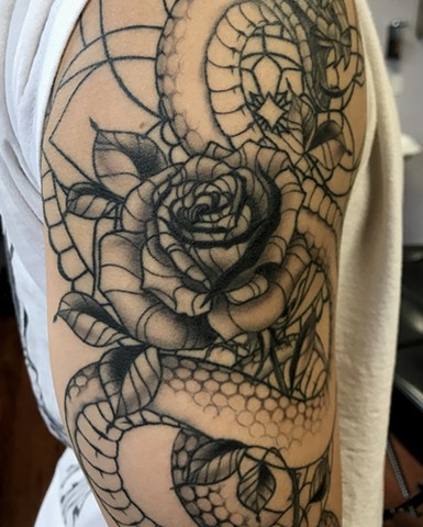 this is a rose with a snake tattoo done in a black work style by Amanda Marie female tattoo artist and tarot reader in los Angeles California at her private studio ace of wands tattoo