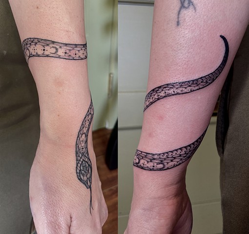 this is a tattoo of a mystic snake done by Amanda Marie tattoo artist and tarot reader in Los Angeles California it is delicate and ornate ornamental black and grey