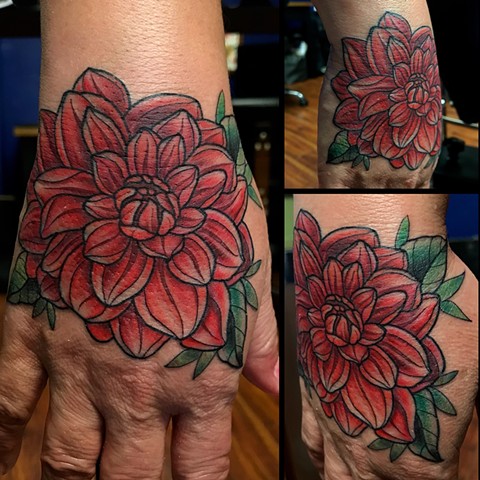this is a hand tattoo of a dahlia flower done by Amanda Marie female tattoo artist in Los Angeles California