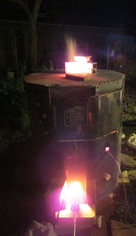 The propane gas kiln firing at night.