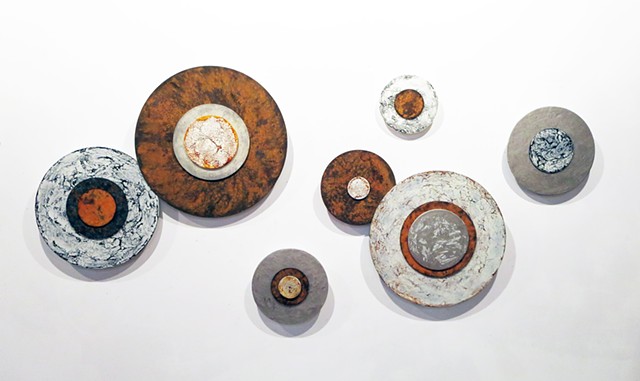 Cotemporary, modern wall sculpture art with rust on dimensional circles on acrylic panels