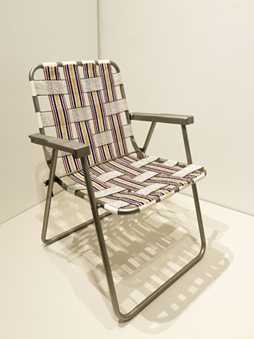A lawn chair covered in loom-beaded sections of glass beads copying an original chair.
