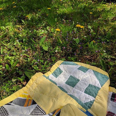 Laying amongst the dandelions on a quilt I snagged from Mom years ago.