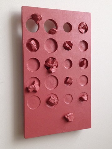 An abstract sculpture. A painted wood, wall relief with marble chip inclusions. "How's to judge? 2015, by Robert Fields