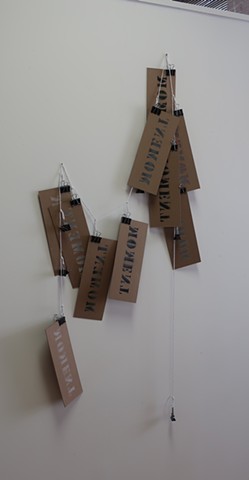 Robert Fields, Contemporary conceptual sculpture / prints. Title: "#1... T Series." 2020. Stenciled lacquer aerosol on chipboard (10) pcs. with metal clamps (16 pcs.) and 100% cotton butcher twine. 51" H x 26" W x 3" D.  Informed by the mind/body shifts t