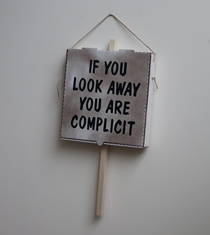 Robert Fields, "IF YOU LOOK AWAY,..." --Ai Weiwei,  2019. Adhesive vinyl, vegetable oil on corrugated paper board, with wood & twine. Speaks to all refugees seeking asylum. 24" H x 13" W x 2-1/4 " D.