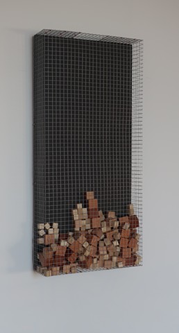 Robert Fields, "Nine Hundred +"  2019. Galvanized steel wire screening with copper & steel fasteners, waxed wood blocks (loose jumble), and acrylic paint on wood panel. 30-1/2 H x 14-1/2 W x 4 D Inches. Contemporary wall sculpture in a minimalist manner.