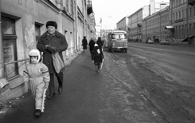 Man and child in fur hats walking along the street
