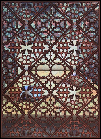 Islamic screen in front of 2 cups on table, looking to horizon through holes