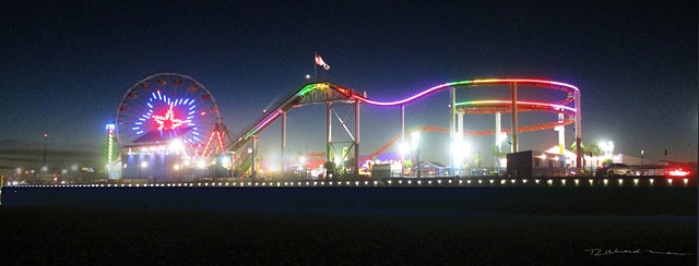 Santa Monica Pier in the Evening with rides  lights and the beach 