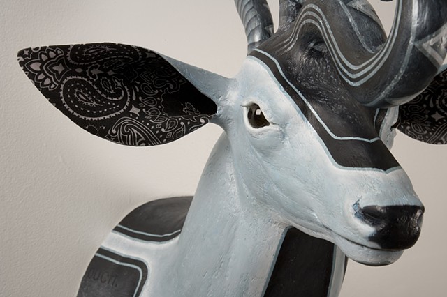 low rider sculpture of a deer with snake on its head and painted with iridescent white and payns gray pin stripping of blue black oil paint