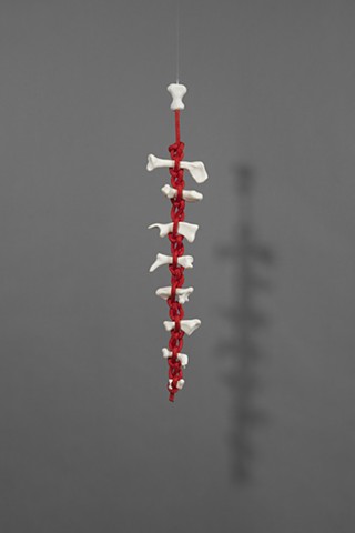 abstract hanging sculpture by Laura Evans suggesting a spine. Figurative