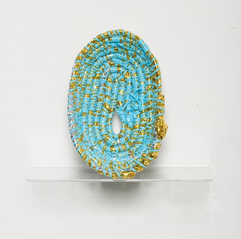 coiled sculpture in gold mylar emergency blankets, baby blue plastic lacing, and baby blue plastic beads by José Santiago Pérez