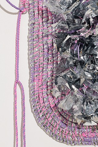 detail of wall based abstract coiled basket made with emergency blankets and lavender and pink plastic lacing by José Santiago Pérez