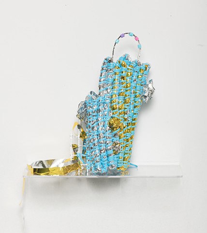 coiled sculpture in silver and gold mylar with baby blue plastic lacing, plastic mesh, silver leaf, and plastic beads by José Santiago Pérez